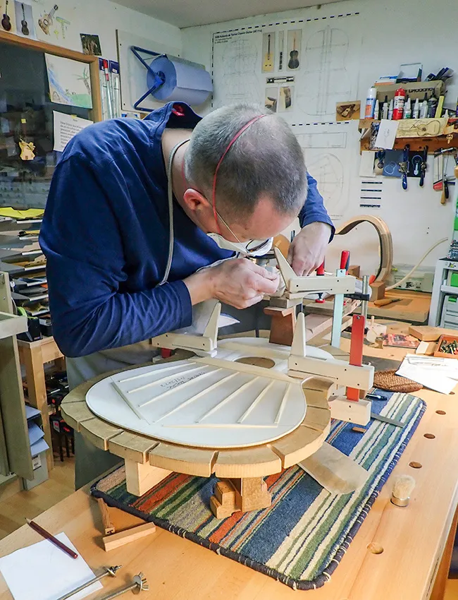 En gitarrmakare jobbar på en ny gitarr